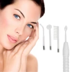 Mujer con piel clara y ojos azules tocando su rostro, junto a un dispositivo de alta frecuencia blanco con cuatro electrodos intercambiables para tratamiento facial y capilar.