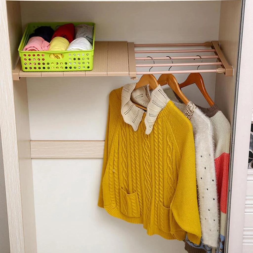 Repisa expandible en madera clara con cesta verde y ropa colgada, ideal para organizar armarios sin obras.