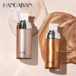 Set de dos iluminadores corporales Shimer de Handaiyan, presentados en envases cilíndricos con acabado metálico dorado y blanco, sobre fondo con textura de crema brillante.