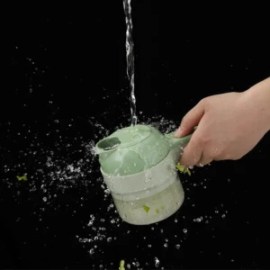 Picatodo portátil manual en color verde claro, con mango ergonómico, siendo enjuagado bajo chorro de agua mientras se lavan restos de verduras.