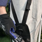 Kit de protección integral para carnaza en uso, con chaleco gris y guantes negros con detalles azules, mostrando sistema de correas y soporte de brazo.