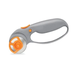 Cortador giratorio con mango ergonómico gris y detalles naranjas, diseñado para manualidades. Incluye rueda de corte con protección naranja.