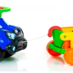 Carro paseador montable para bebés en azul brillante con detalles negros y luces frontales, conectado mediante cuerda a remolque de juguete multicolor con ruedas naranjas y verdes.