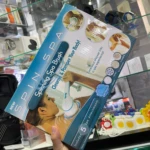 Cepillo eléctrico para ducha con cabezales giratorios, en caja azul mostrando uso y accesorios incluidos.