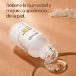 Bote de Serum Reafirmante de Arroz con Ácido Hialurónico, presentación transparente con etiqueta blanca y detalles dorados, sobre fondo beige con gota de suero y granos de arroz.