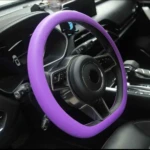 Volante de coche con forro de silicona antideslizante en color morado, instalado en interior de vehículo, mejora el agarre y protege contra el calor.