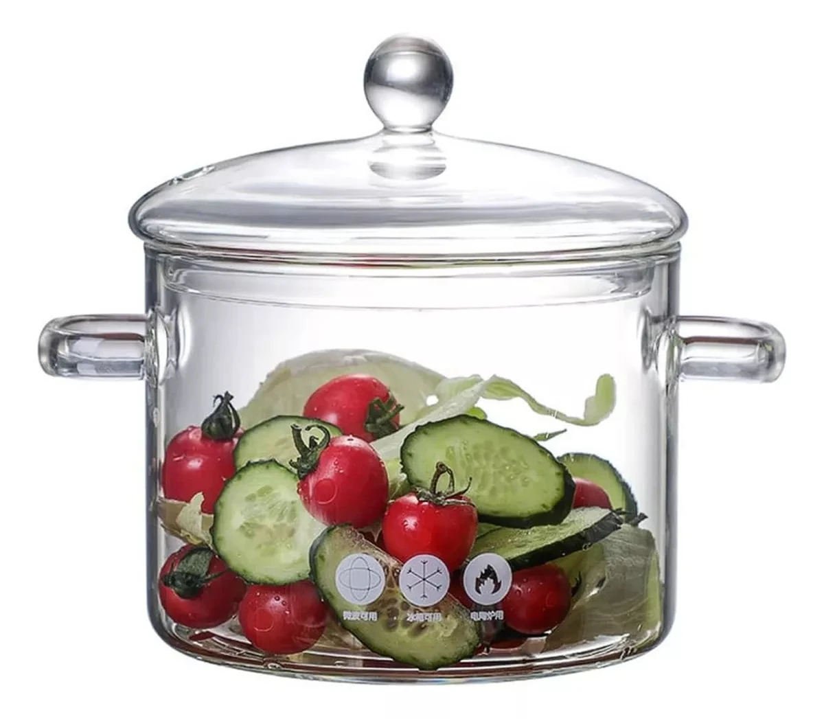 Olla de vidrio transparente con tapa y asas laterales, mostrando vegetales frescos como tomates cherry, pepino y lechuga.