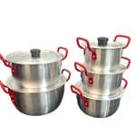 Set de cinco ollas de aluminio con asas rojas, apiladas en dos grupos, mostrando tapas negras y superficie metálica brillante.
