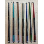 Taco de billar desarmable de madera en tonos negro, azul, verde, rojo y madera natural, con eje de baja desviación, alineado verticalmente sobre superficie texturizada.