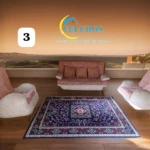 Alfombra tipo persa de 2x1,50m con base antideslizante, vista cenital en sala con sillones y sofá frente a ventana con paisaje.