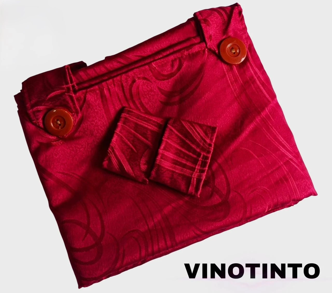 Cortina persa en tela jacquard color vino tinto, con botones decorativos y patrón floral sutil, vista frontal plegada.