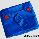 Cortina persiana azul rey en tela jacquard, vista frontal con botones rojos y pliegues decorativos.