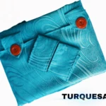 Cortina persiana en tela Jacquard color turquesa, con diseño ondulado y botones naranjas visibles en la parte superior.