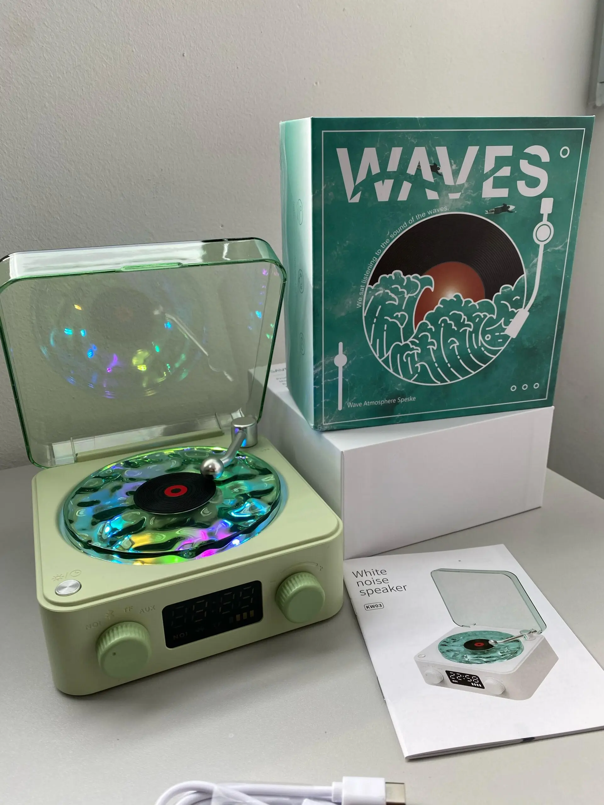 Parlante retro color verde menta con tapa transparente, disco holográfico y luces RGB. Incluye caja, manual y cable USB.