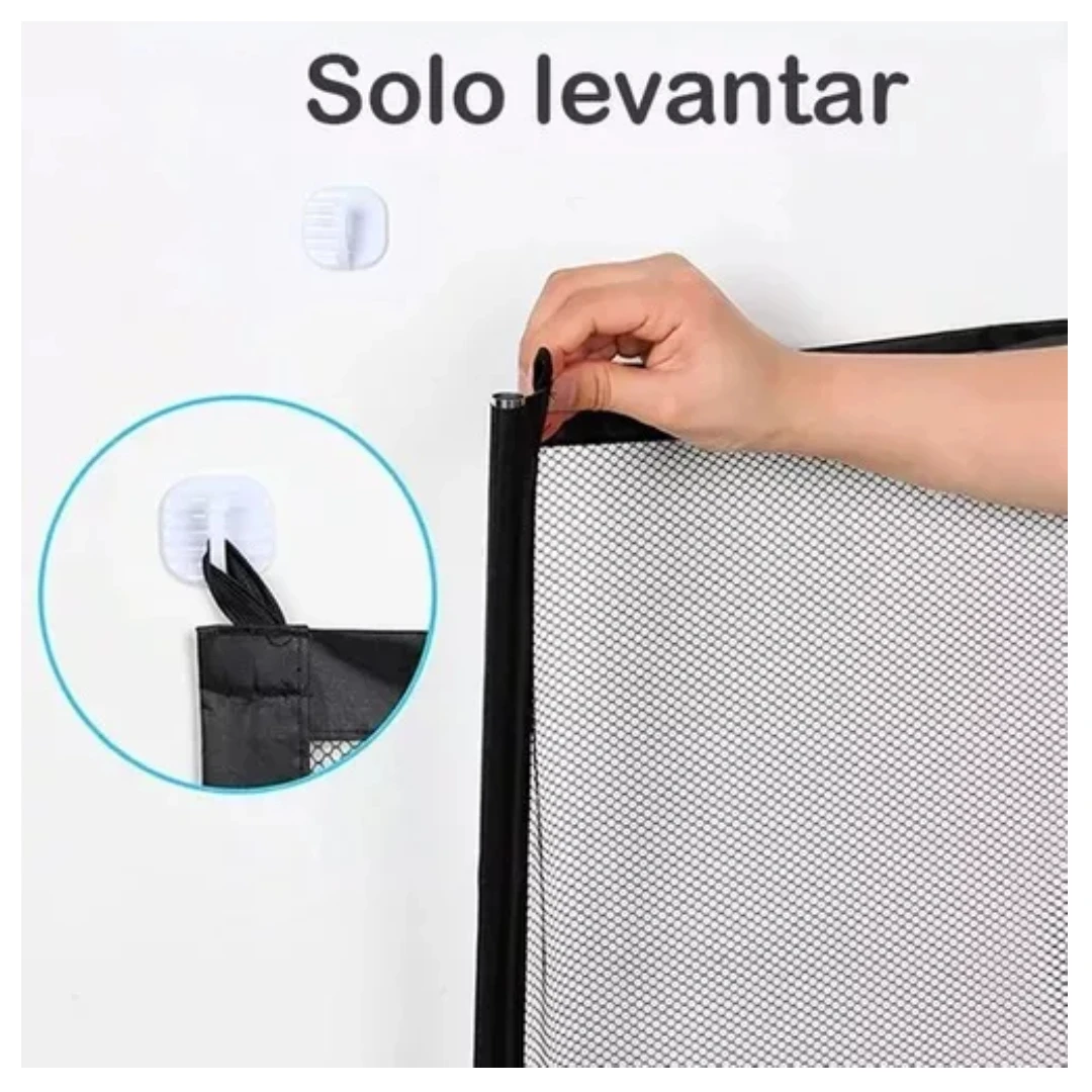 Mano sujetando borde negro de red malla seguridad portátil, con ganchos adhesivos blancos en pared blanca. Detalle circular muestra instalación del gancho con tela negra.