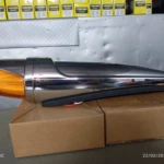 Bala misil grande de policarbonato con acabado cromado y luz ámbar trasera, sobre caja de cartón en almacén.