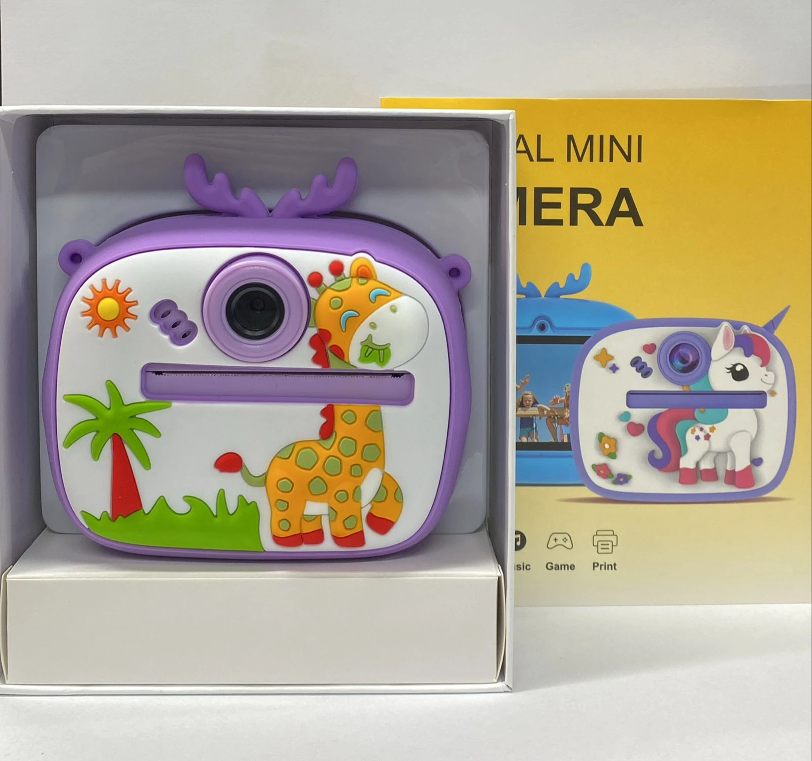 Cámara digital infantil con temática de unicornio, color morado y blanco, en caja abierta mostrando el producto principal y su diseño decorativo.