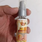 Bote de 20 ml de spray antimicótico con etiqueta que muestra abejas y uñas afectadas, sostenido en mano.