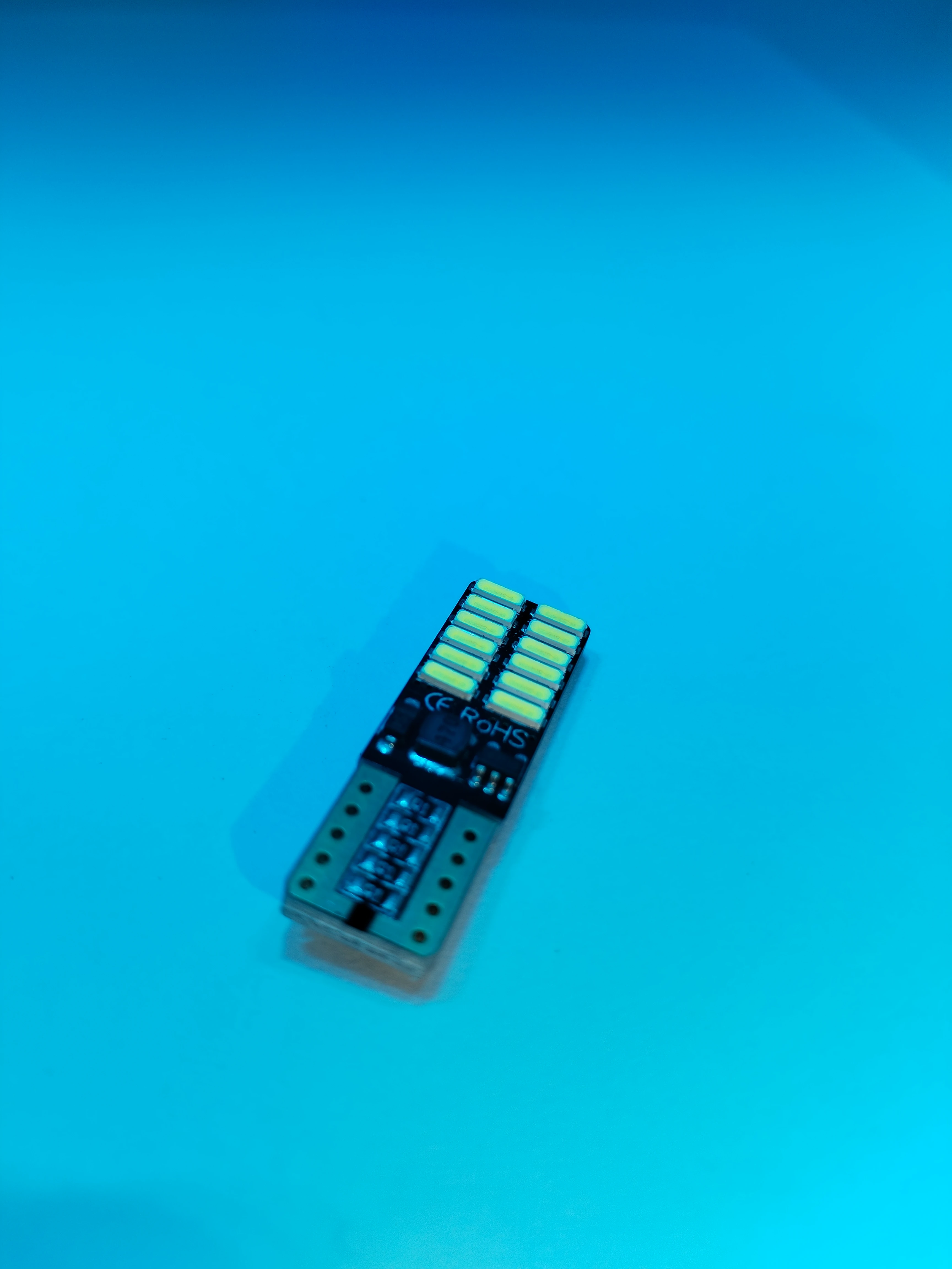 Paleta de luces LED Cocuyo de 12V, vista cenital sobre fondo azul. Incluye tres módulos rectangulares con diodos amarillos y conectores metálicos en la base.