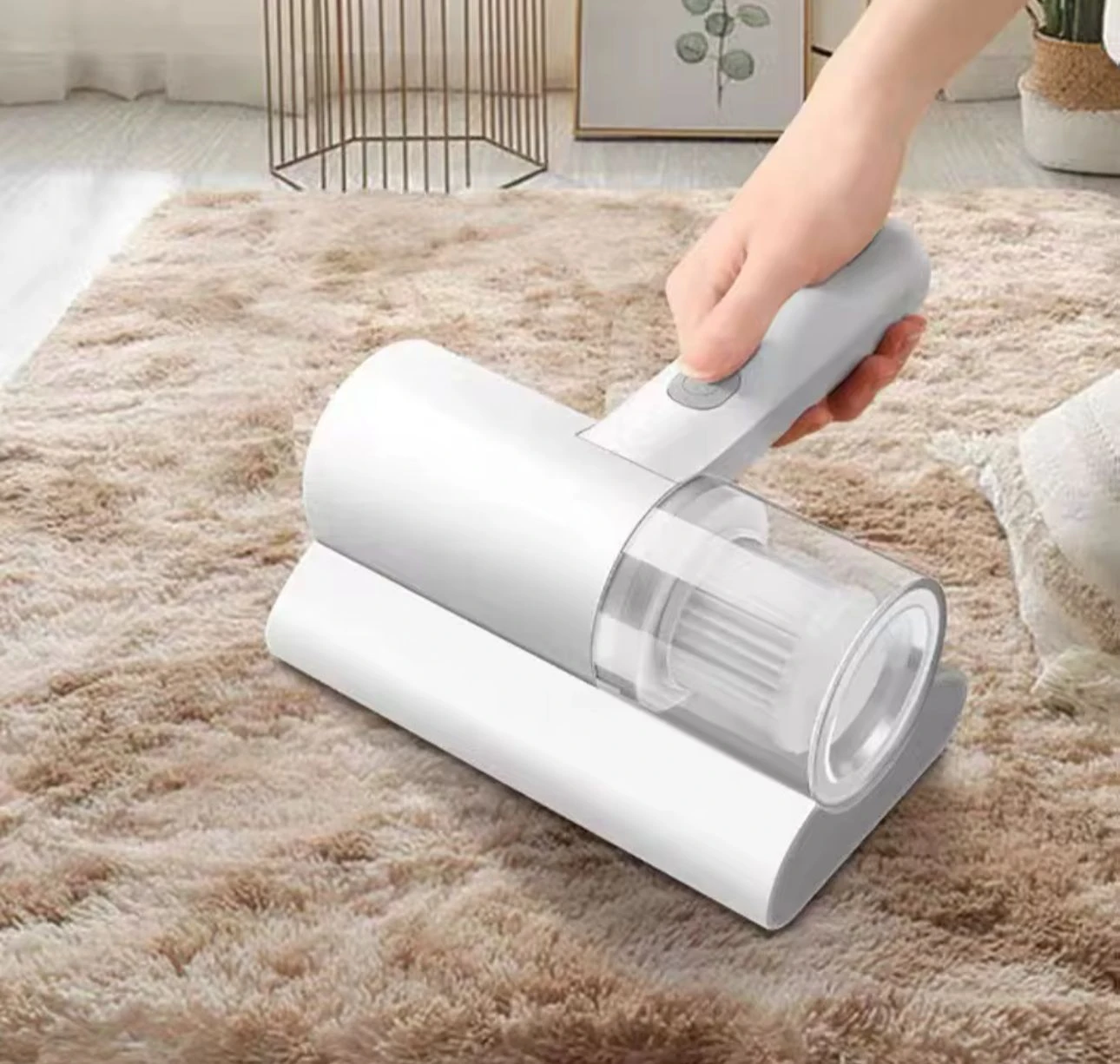 Aspiradora de mano portátil blanca con filtro HEPA, en uso sobre alfombra beige, eliminando ácaros y alérgenos de sábanas y tapicería.