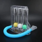 Espirómetro incentivo con tres tubos transparentes, cada uno con una bola de colores (amarillo, blanco y verde), conectado a un tubo flexible azul y filtro nasal blanco.