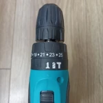 Taladro inalámbrico Makita 1802 en color azul turquesa, con mandril ajustable y escala de tuerca visible (19–25 mm), sobre superficie de madera clara.