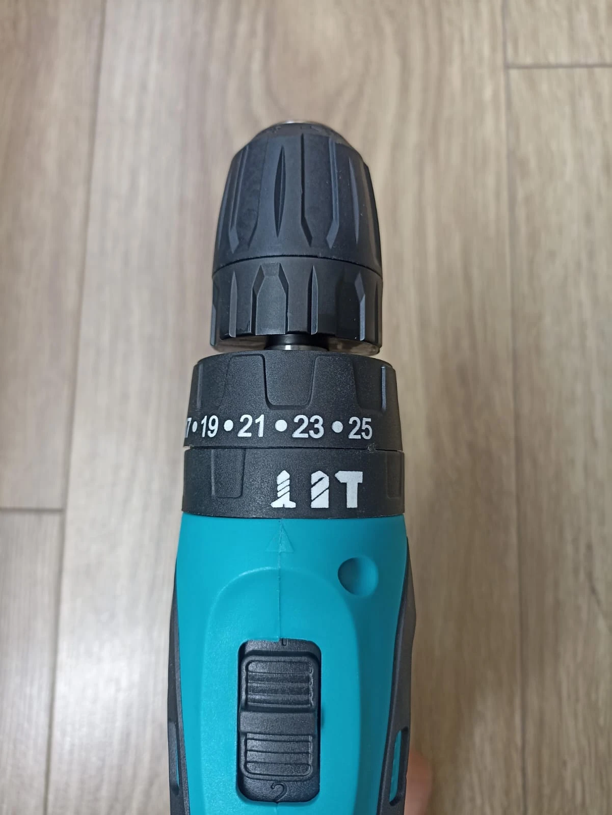 Taladro inalámbrico Makita 1802 en color azul turquesa, con mandril ajustable y escala de tuerca visible (19–25 mm), sobre superficie de madera clara.