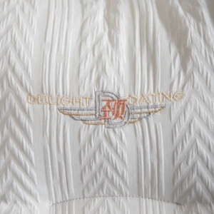 Almohada ergonómica Spazios en color blanco con textura de ondas y bordado central que dice Delight Boating.