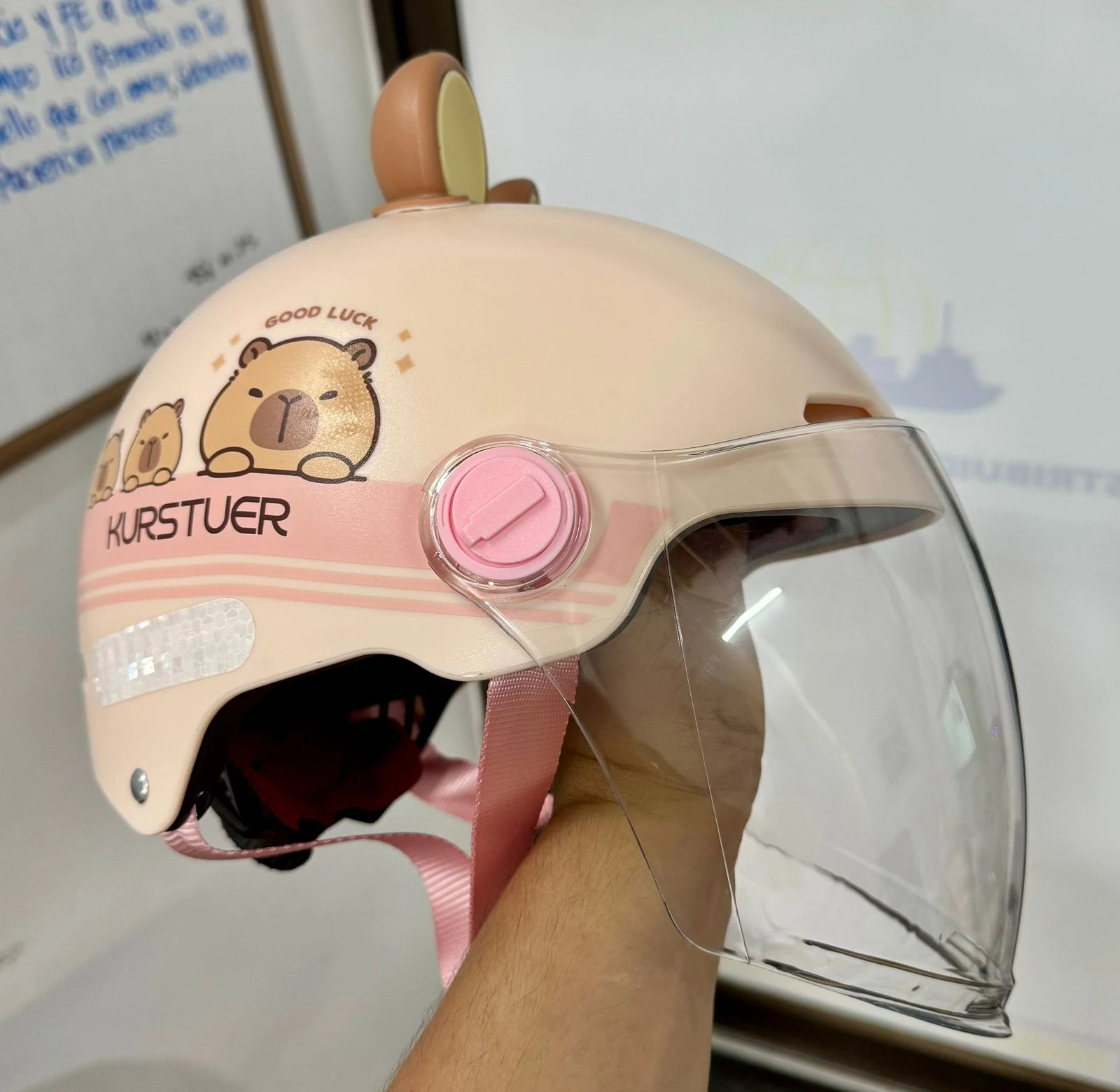 Casco juvenil color crema con diseño de capibara y visor transparente extendido, ideal para proteger rostro del viento y suciedad.