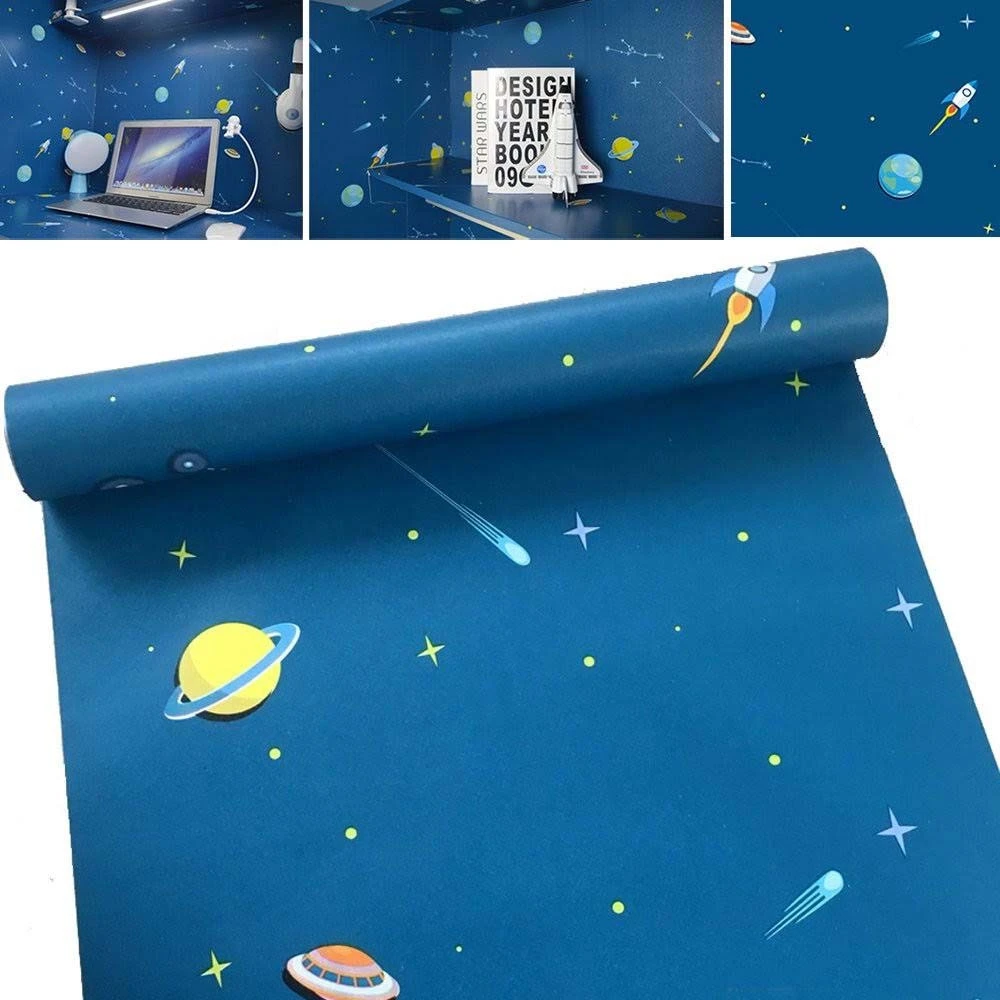 Papel adhesivo decorativo espacial azul mate con planetas, estrellas, cohete y cometa; muestra aplicación en pared y detalle de rollo desenrollado.