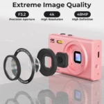 Cámara digital rosa con lente desmontable, sensor visible y anillos de zoom; destaca calidad 4K y 48MP en diseño compacto.