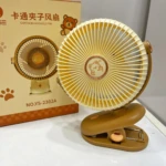 Ventilador mini portátil color beige con diseño de oso, montado en pinza para superficies. Incluye caja original con del producto y modelo NO.YS-2302A.