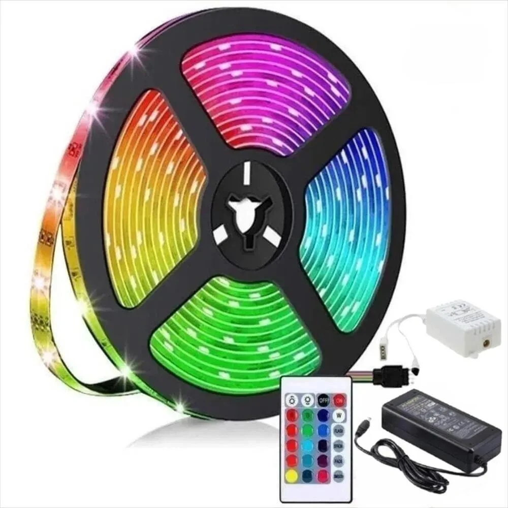 Cinta LED RGB de 5 metros enrollada en bobina negra, mostrando luces multicolores en espiral, con control remoto, adaptador y transformador incluidos.
