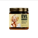 Jarra de vidrio con tapa dorada que contiene crema Evil Goods, etiqueta con retrato de Marilyn Monroe y texto en inglés.