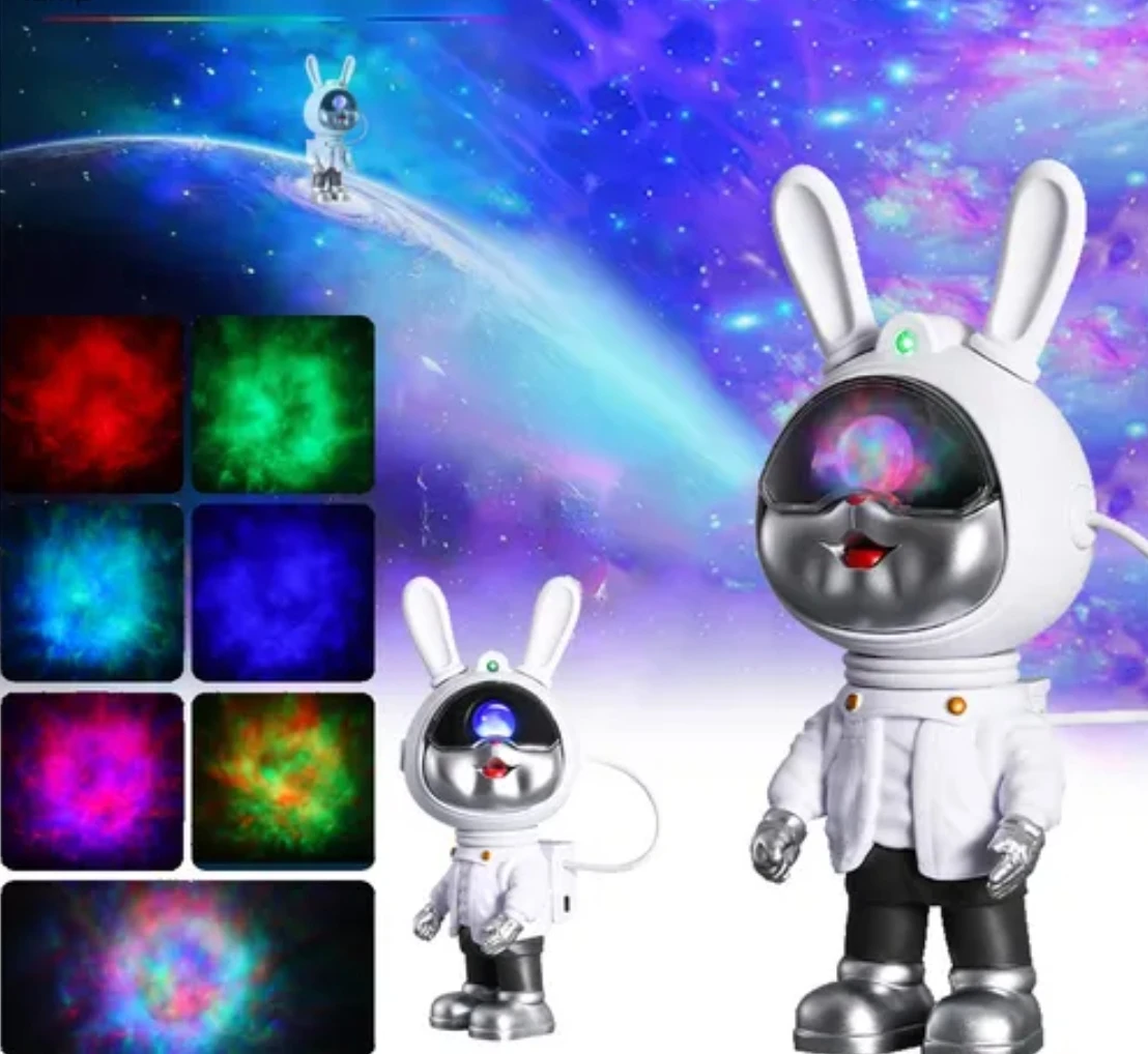 Proyector de galaxias en forma de conejo astronauta, con visor multicolor y antenas blancas. Incluye panel de luces LED en tonos neón y versión pequeña junto a la grande.