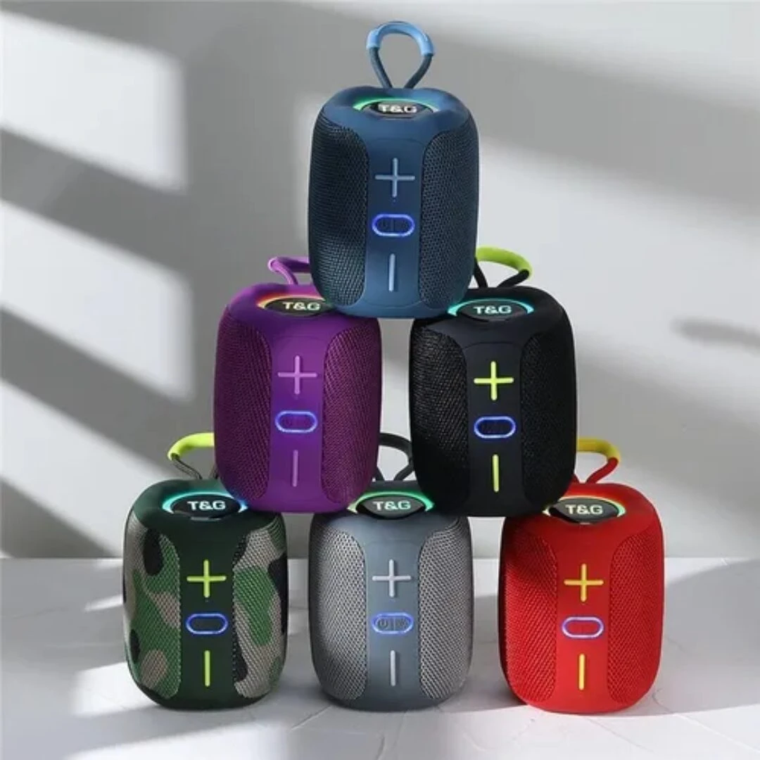 Pila de seis parlantes portátiles T&G modelo 658 en colores azul, negro, morado, verde camuflaje, gris y rojo, con botones de control visibles y asas superiores.