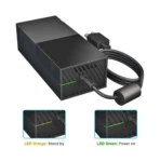 Fuente de alimentación externa negra para Xbox One, con cable enrollado y luces LED naranja en espera y verde encendido.