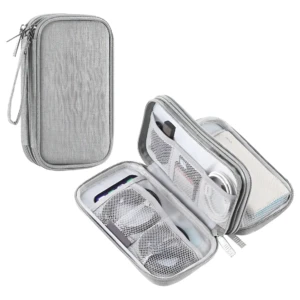 Organizador de cables Oxford compacto en color gris claro, con textura de lona y cierre de cremallera. Muestra la versión cerrada y abierta, revelando compartimentos internos con malla para organizar accesorios electrónicos.