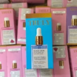 Pack de dos aceites corporales Truly Glass Skin con Bakuchiol y Vitamina C, en caja azul con detalles dorados, presentación vertical sobre estantería con productos similares en tonos rosa y morado.