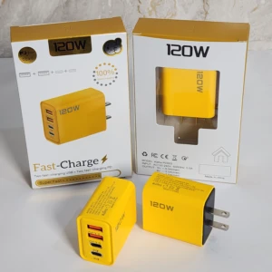 Adaptador de pared amarillo de 120W con cuatro puertos USB, mostrando caja y dos unidades físicas sobre superficie blanca.