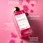 Aceite corporal Truly Birthday Sex en frasco rectangular transparente con líquido rosa brillante, rodeado de gotas del mismo tono sobre fondo rosa pálido. Etiqueta blanca con texto negro y detalles en dorado.