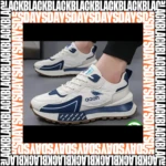 Zapatilla deportiva blanca con detalles en azul marino, diseño retro con suela gruesa y logo visible en lateral. Vista frontal de pie con cordones blancos y textura de goma en suela.