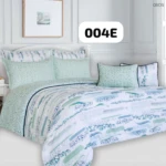 Plumón estampado con motivos florales en tonos menta y azul sobre fondo blanco, presentado en cama con cojines combinados.