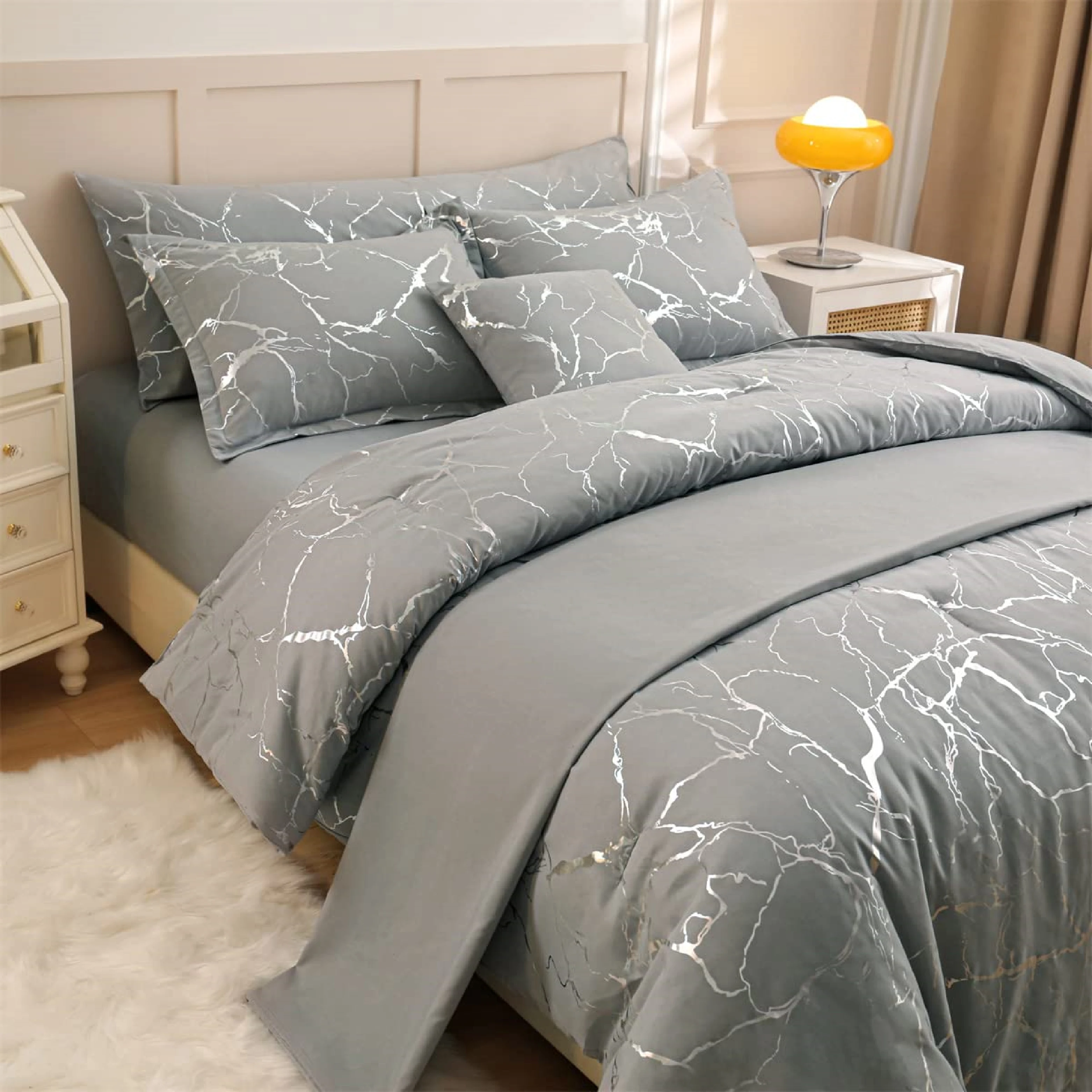 Funda duvet gris con diseño mármol plateado, vista frontal en cama con cojines y mesitas de noche.