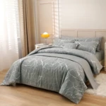 Funda duvet gris con diseño mármol plateado en cama de dos plazas, con cojines a juego y mesita lateral con lámpara amarilla al fondo.