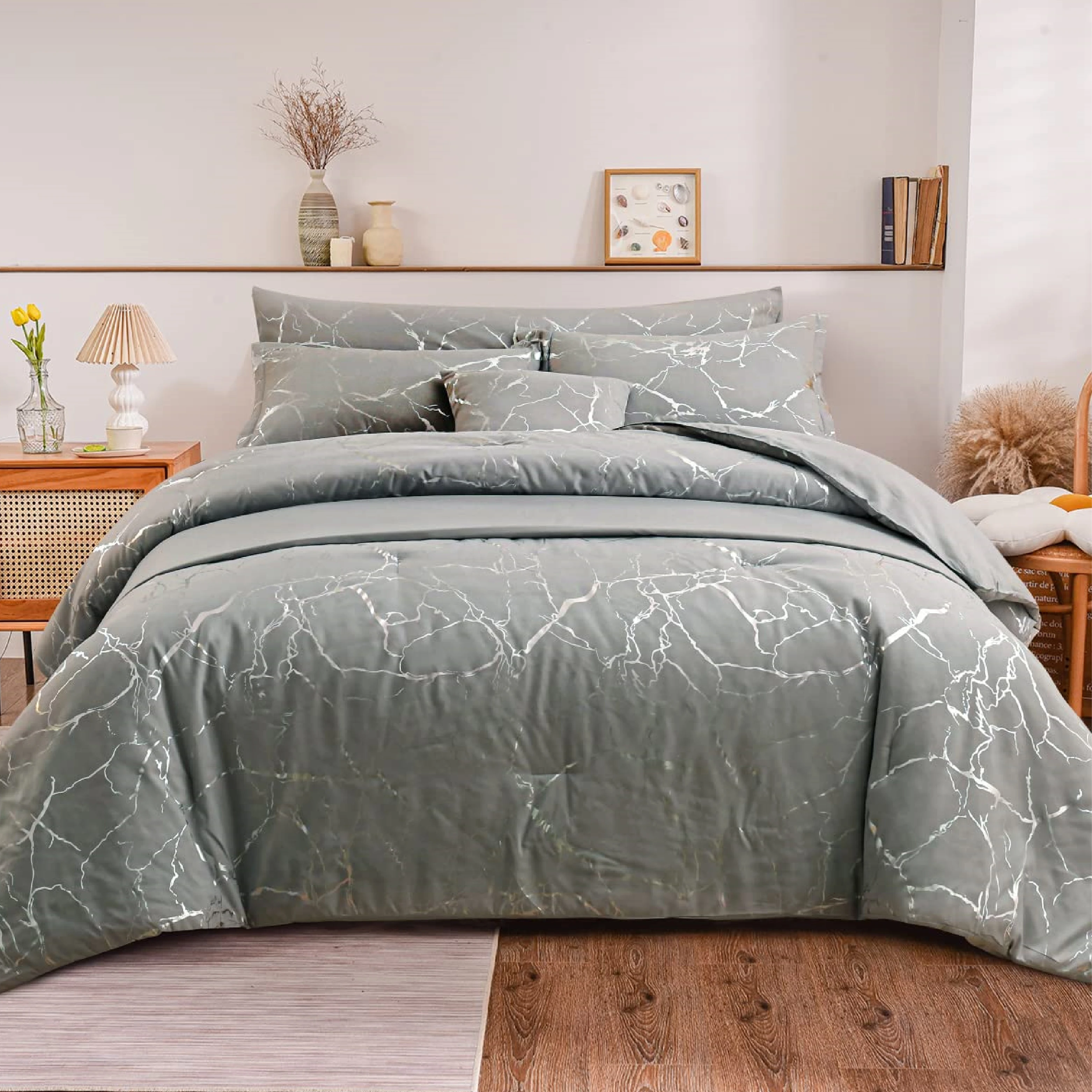 Funda duvet gris con vetas plateadas estilo mármol, colocada en cama con almohadas y cojines a juego, en habitación con estantería decorada.