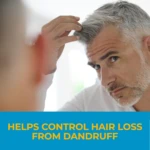 Hombre con cabello gris y barba corta mirando al espejo mientras toca su cuero cabelludo, con texto que indica ayuda para controlar la pérdida de cabello por caspa.