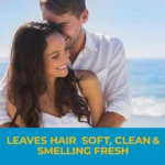 Pareja sonriente en la playa con cabello largo y lacio, bajo luz natural diurna. Fondo marino azul claro y cielo despejado.