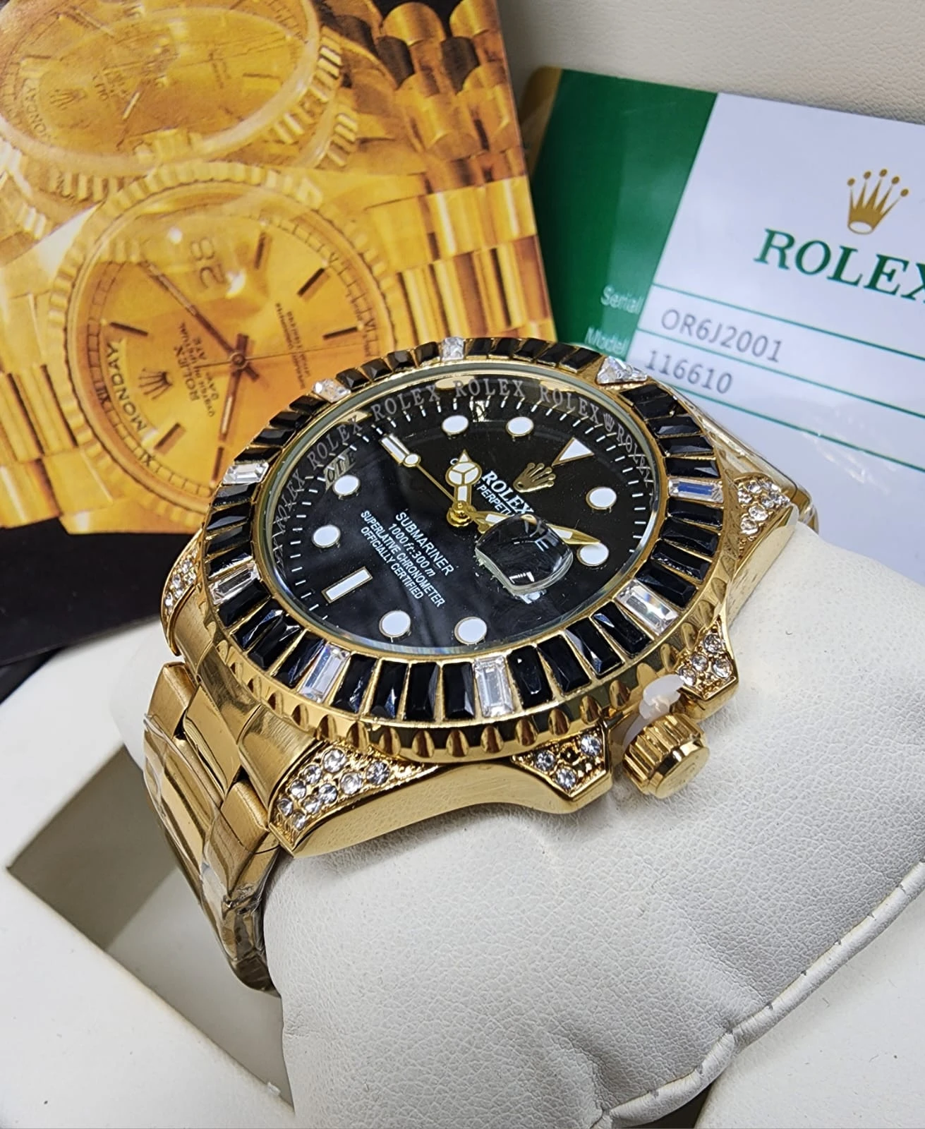 Reloj Rolex dorado con esfera negra, bisel de zafiro y correa de oro, sobre soporte blanco junto a caja y certificado.