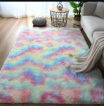 Tapete peludo grande de alta densidad con diseño multicolor pastel, colocado en sala junto a sofá y mesa auxiliar.